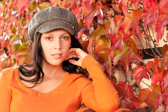 Autumn fashion young woman in front of red colored wild wine leafs