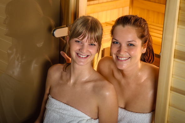Two women at sauna wrapped in towel