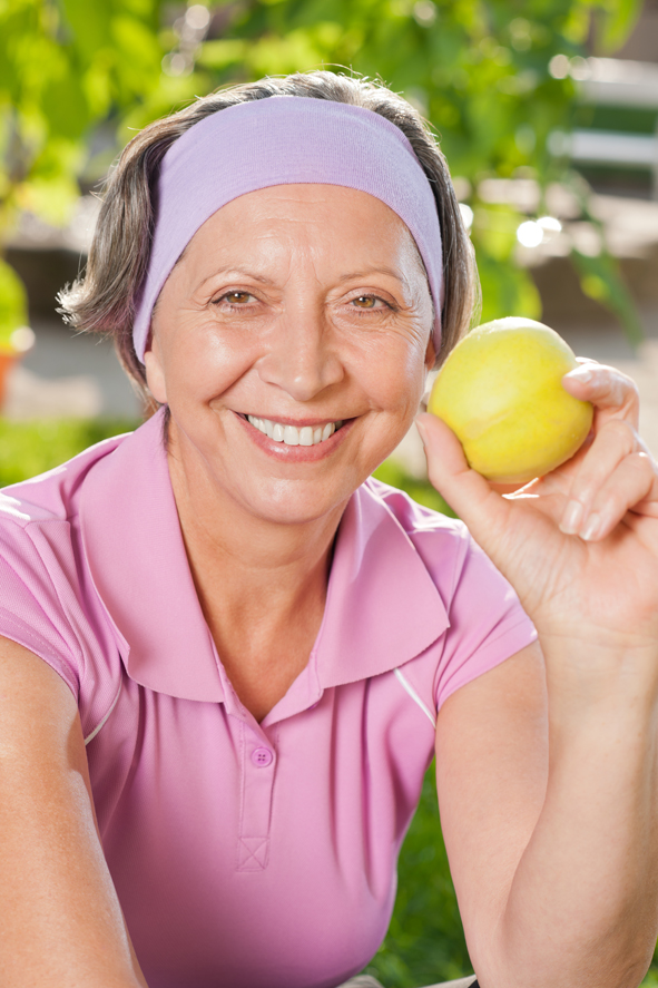 Senior sportive woman smile eat apple outdoor